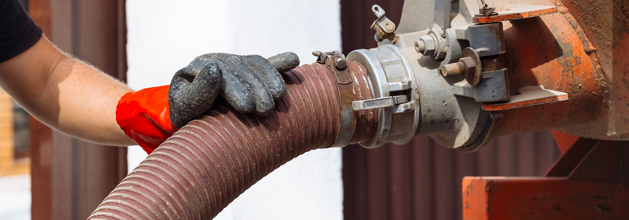 Worker handling large industrial hose connection